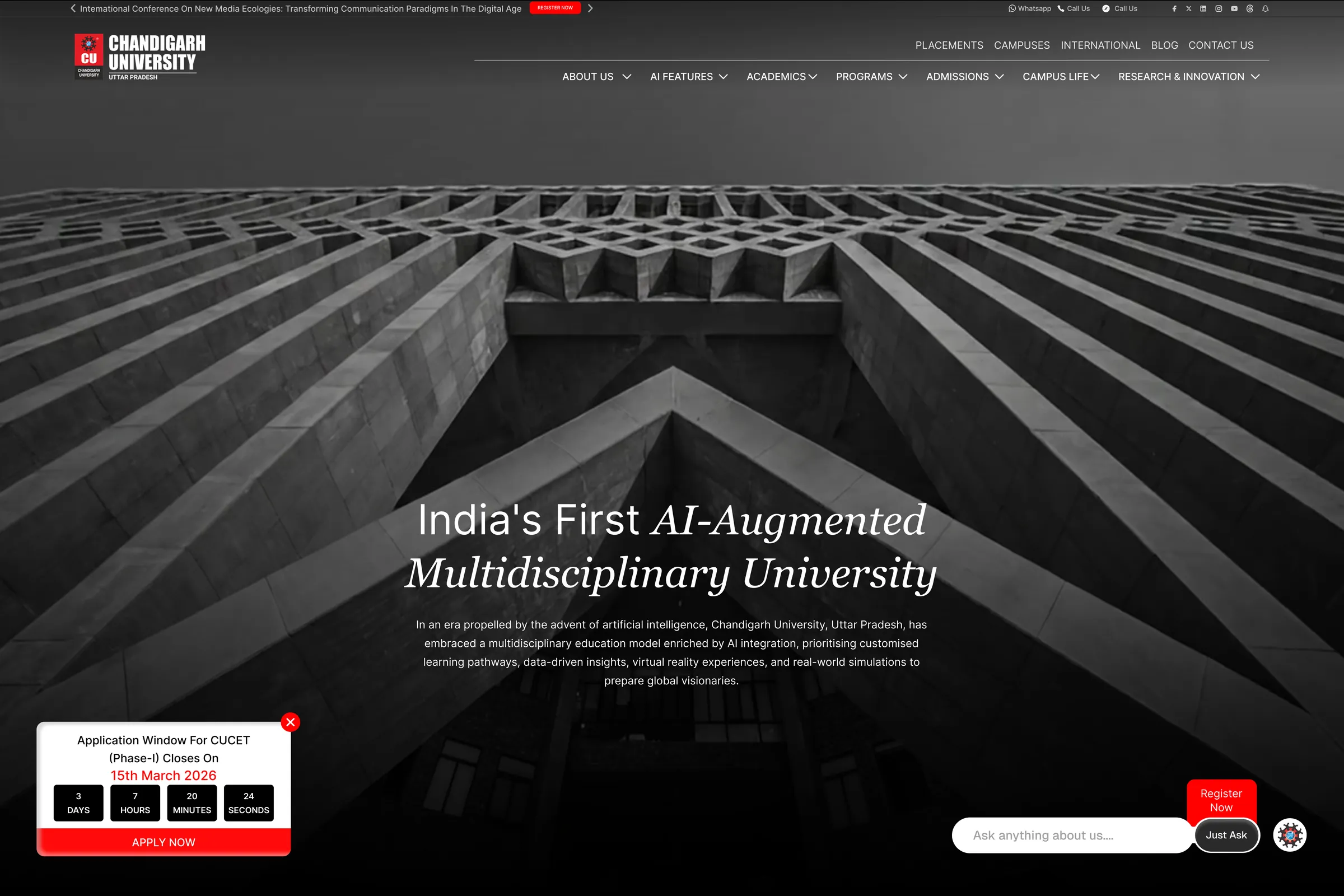 The shipped hero: the campus’s concrete lattice shot from below in black and white, “India’s First AI-Augmented Multidisciplinary University” with the last three words in italic serif, the full navigation, an application countdown and an “Ask anything about us” bar